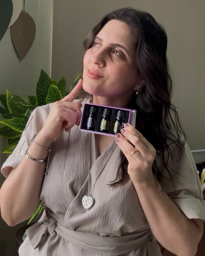 Janaína segurando um kit de óleos essenciais